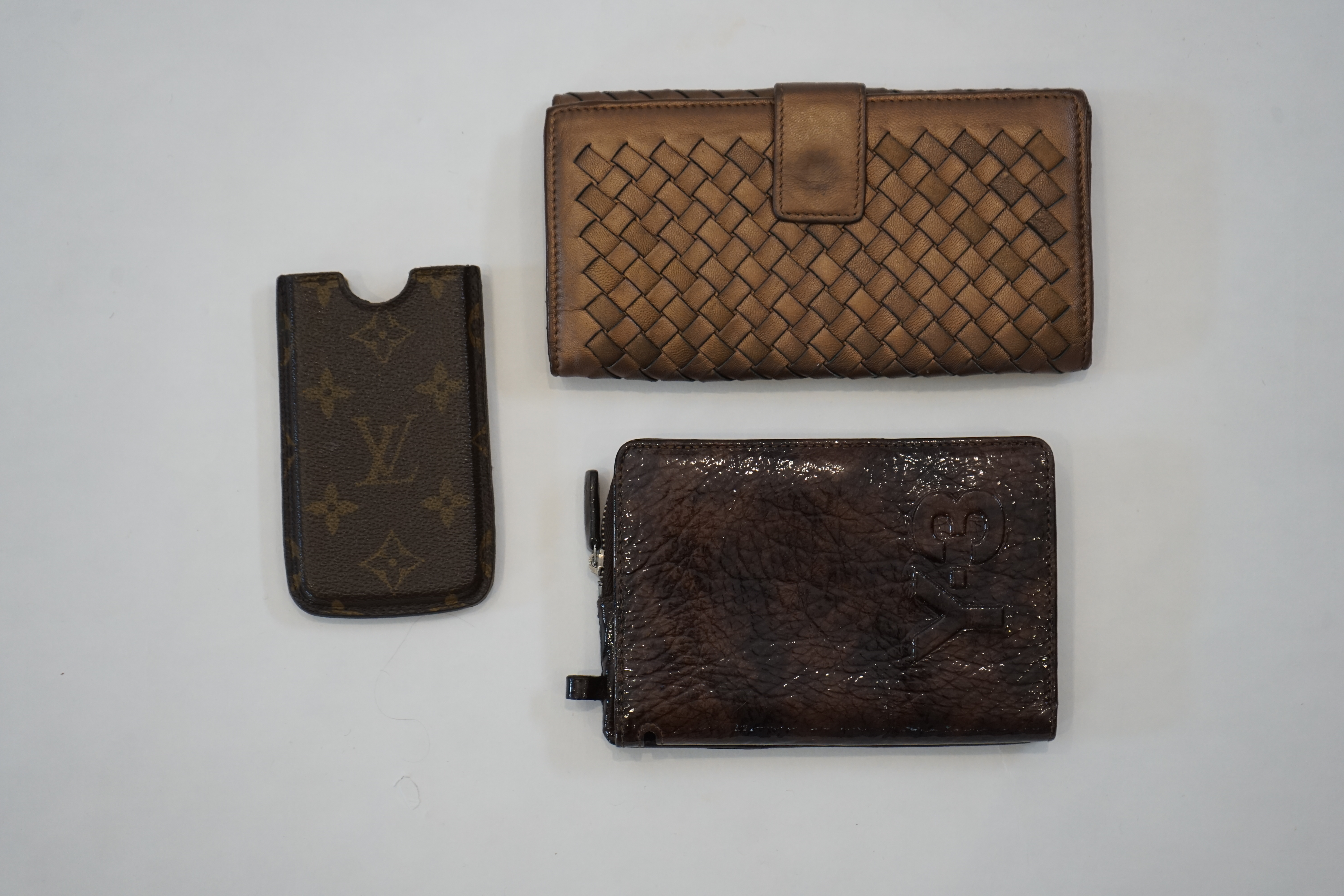 A Bottega Veneta purse, a Y-3 purse/wallet and a Louis Vuitton phone case